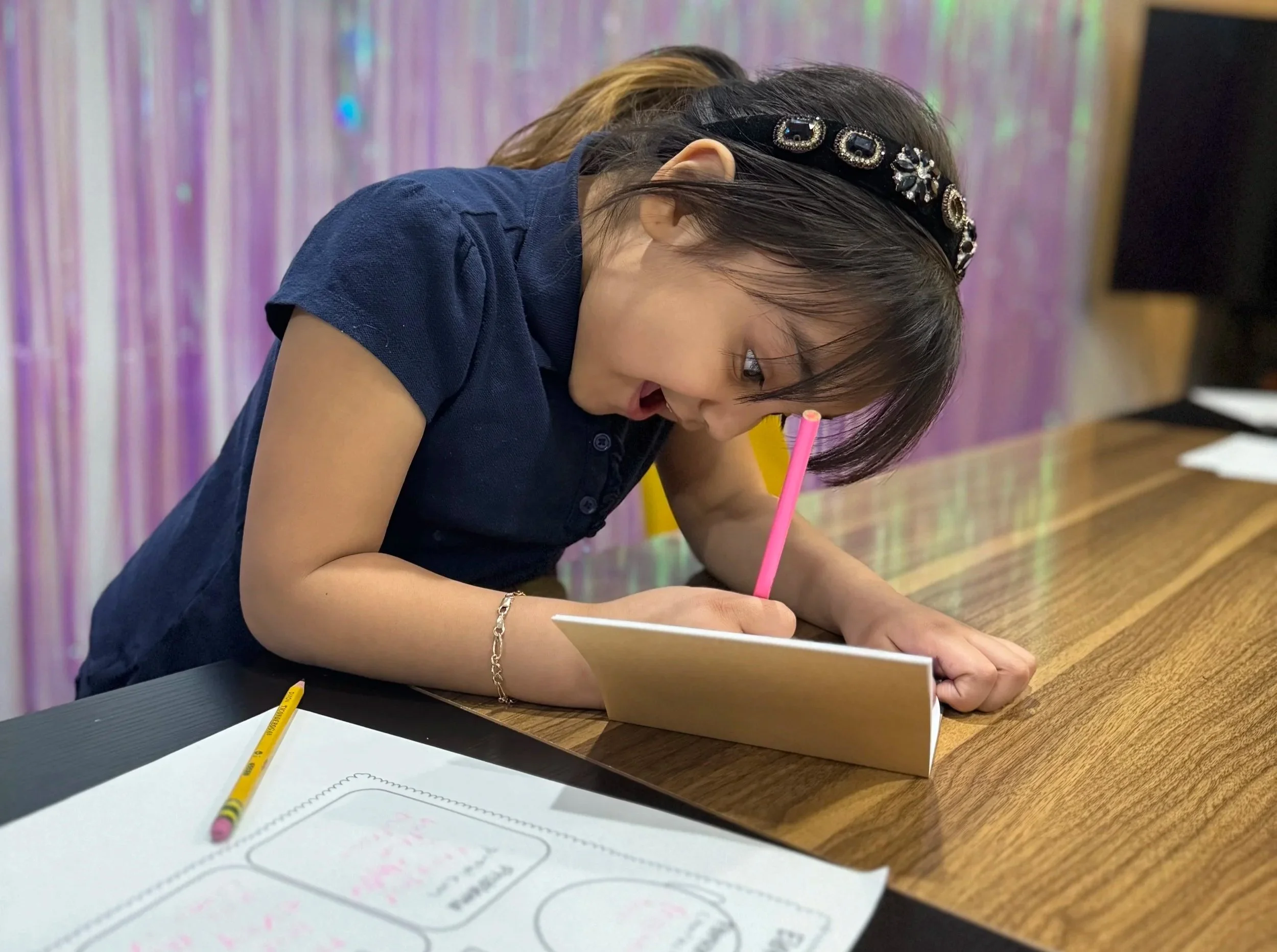 A child writing in a notebook during a GPLXC deployment event