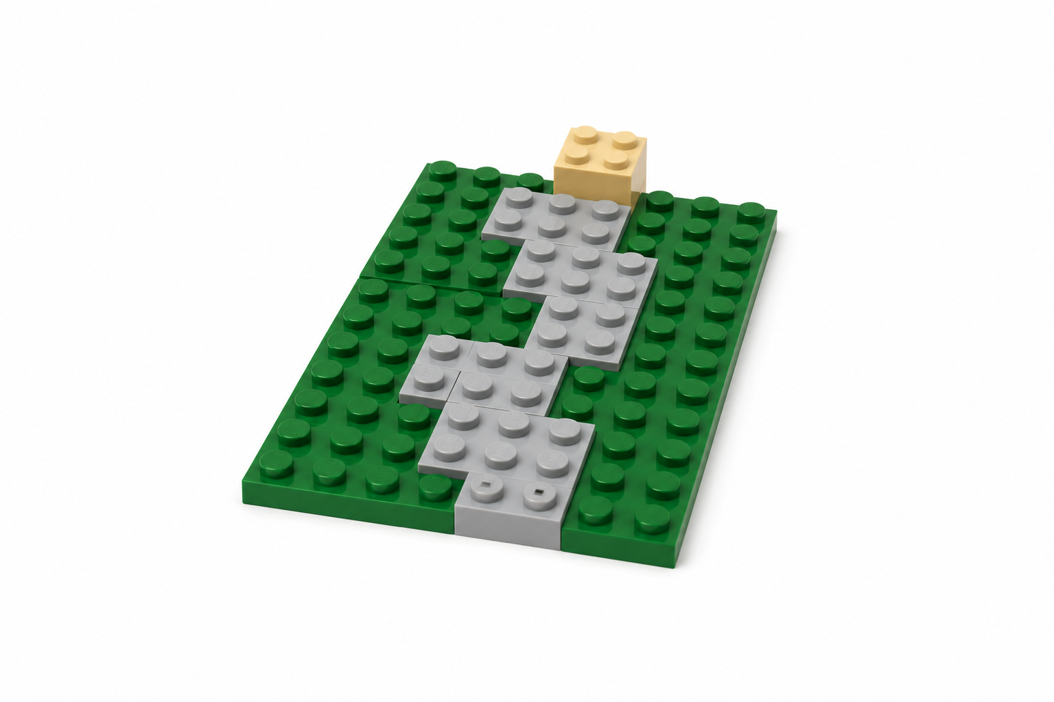 LEGO path of light gray bricks winding across a green baseplate