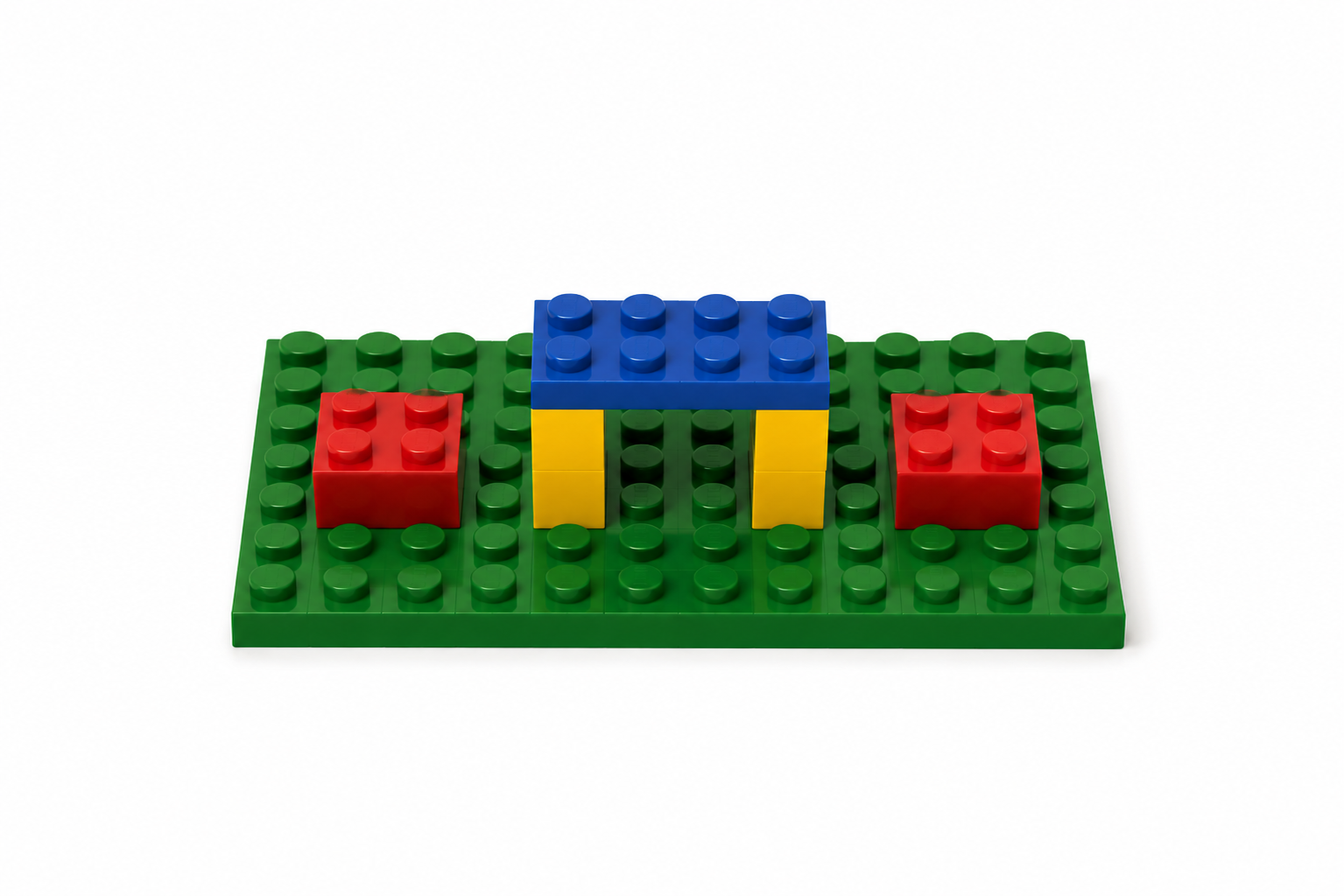 LEGO working space with a blue bridge structure and red blocks on a green baseplate